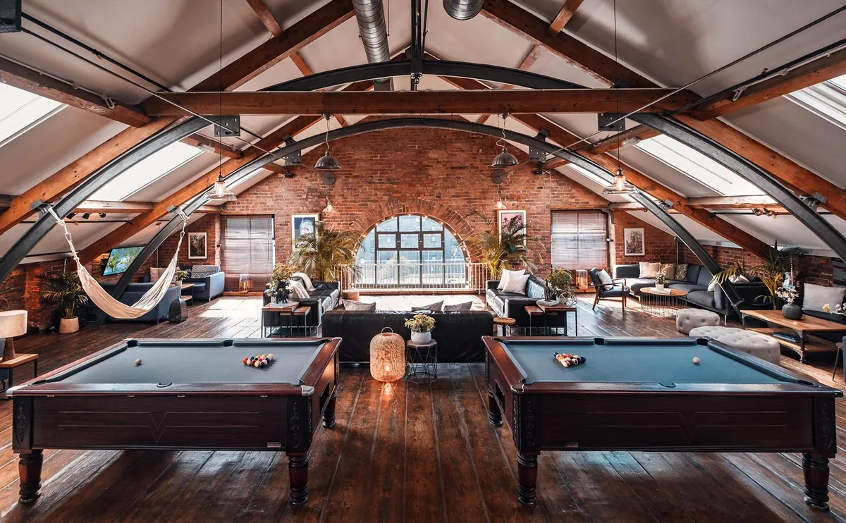 The upper lounge at Beehive Lofts, with pool tables, a hammock and arched windows