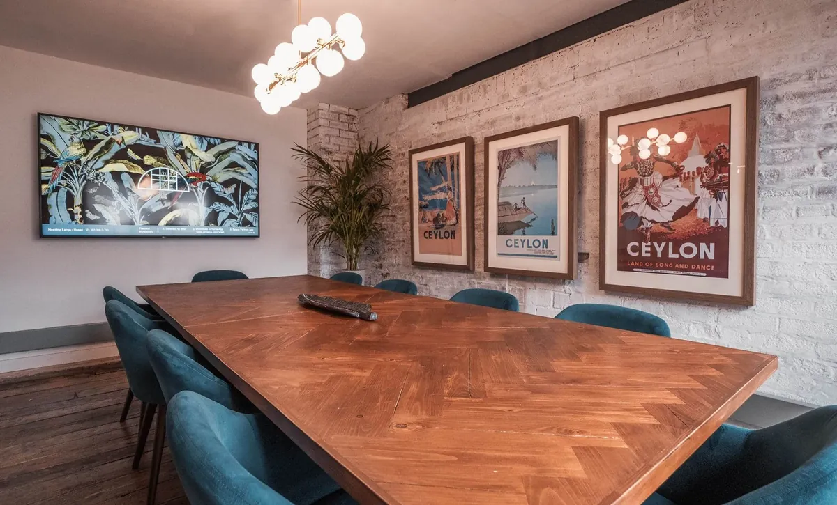 Meeting room with teal chairs and travel posters
